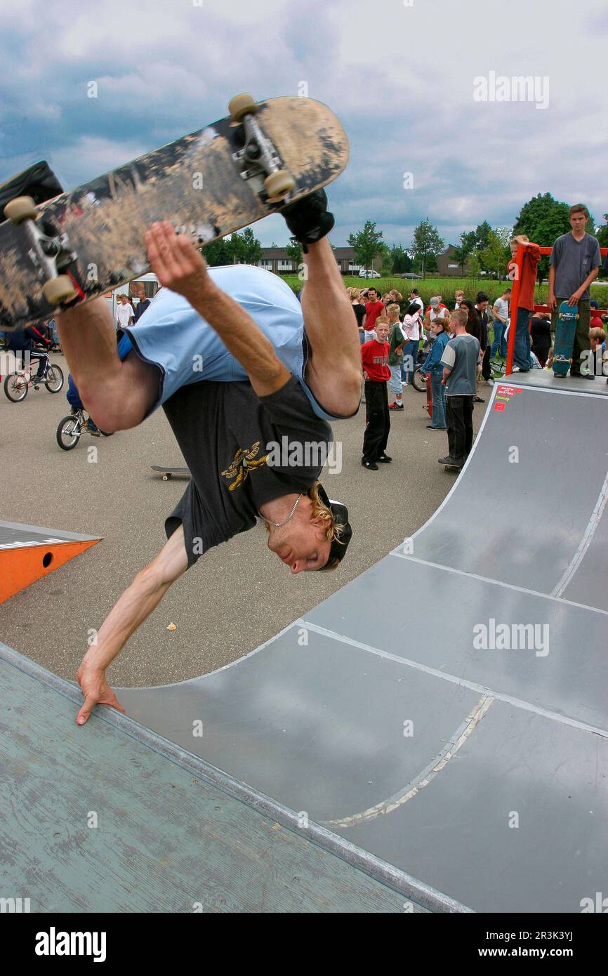 Netherlands, in Zutphen skateboarders perform tricks on a halfpipe in a city suburb. Stock Photo