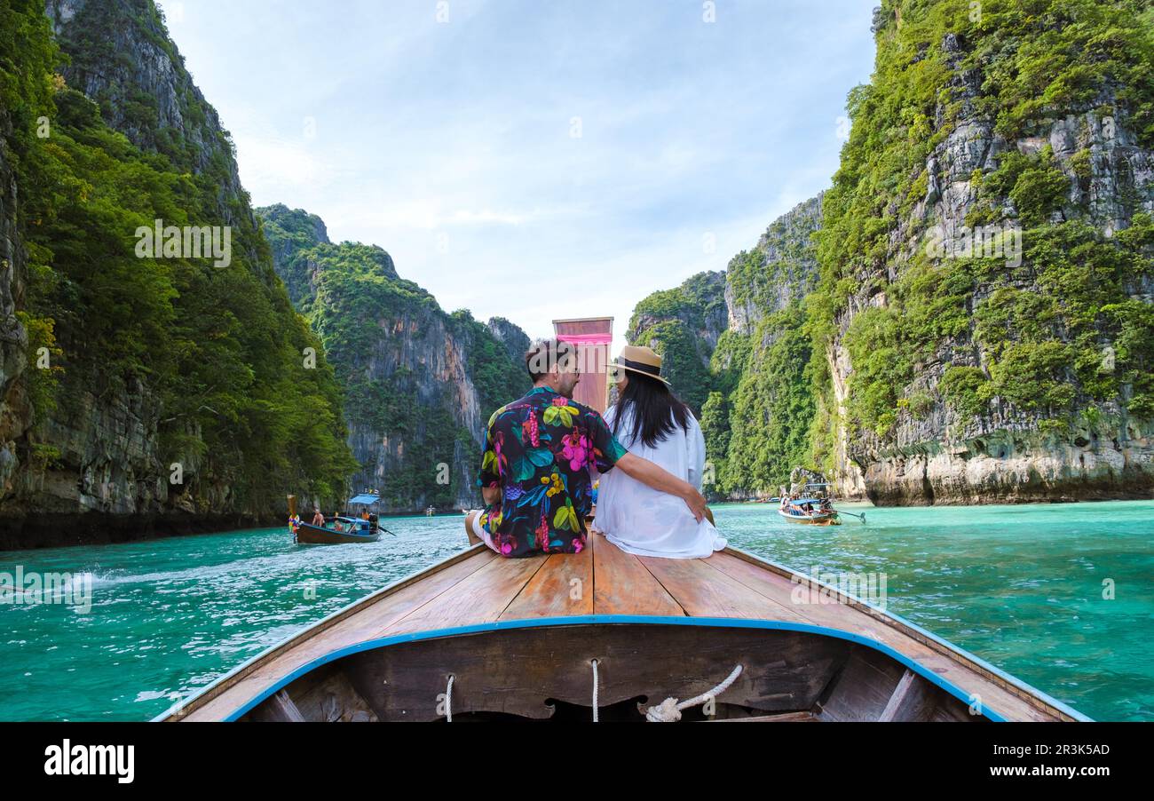 Couple in front of Longtail boat at the lagoon of Koh Phi Phi Thailand Stock Photo