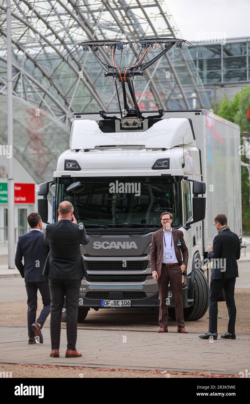 Leipzig, Germany. 24th May, 2023. Participants at the World Summit of Transport Ministers stand in front of an electrically powered truck with a pantograph. Experts from the transport sector from 80 countries will meet here from May 24 to 26. Among other things, the meeting will begin with forecasts for global traffic volumes up to 2050, the International Transport Forum (ITF) announced ahead of the meeting. In addition, global CO2 emissions will be examined and conclusions drawn for transport policy. Credit: Jan Woitas/dpa/Alamy Live News Stock Photo