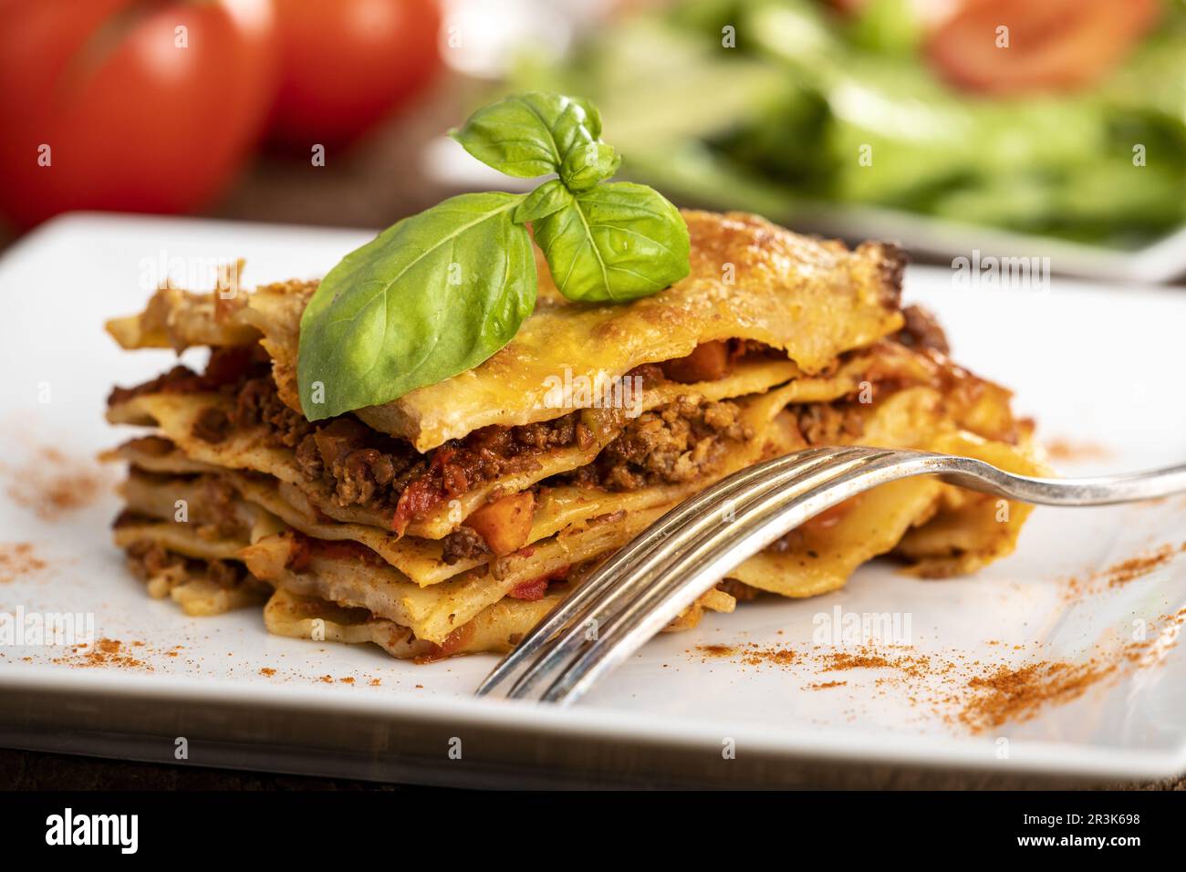 Lasagna on a plate with salad on wood Stock Photo