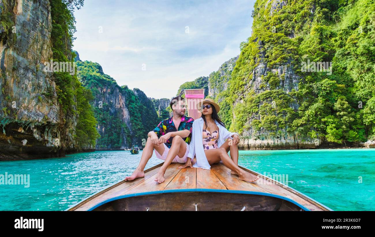 Couple in front of Longtail boat at the lagoon of Koh Phi Phi Thailand Stock Photo