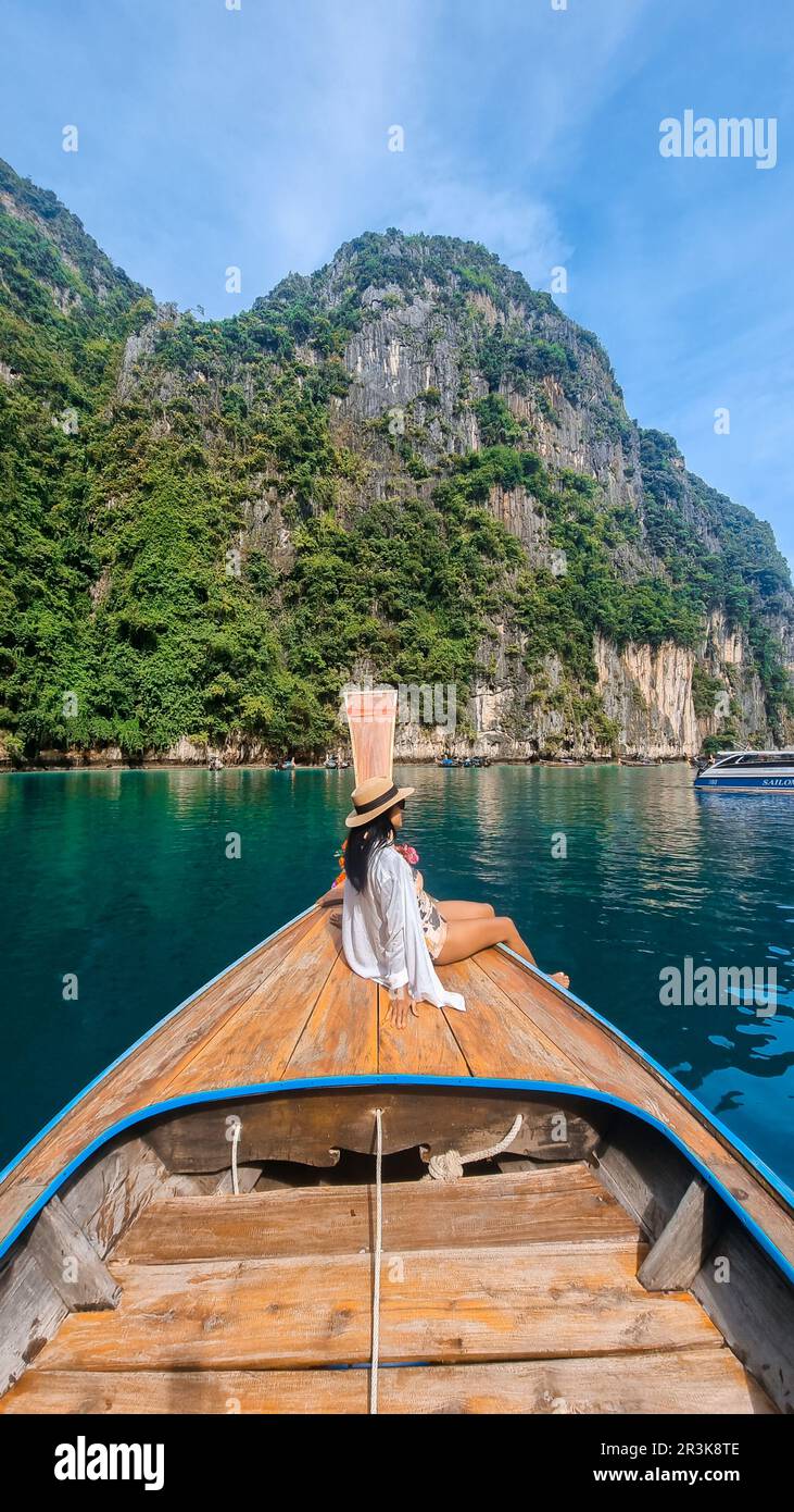 Asian Thai women in front of a Longtail boat at Pileh Lagoon Koh Phi Phi Thailand Stock Photo