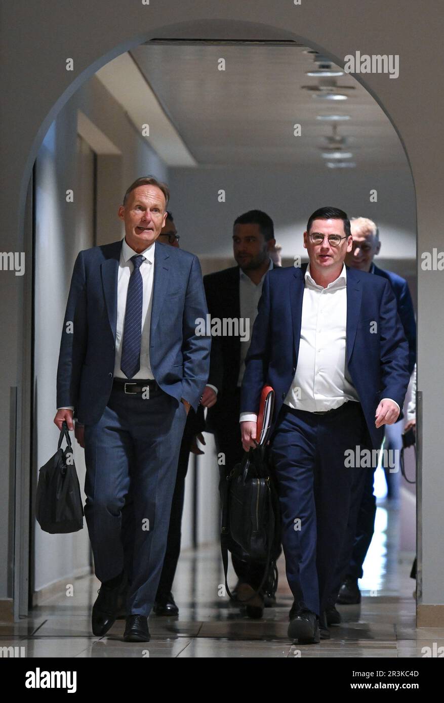 24 May 2023, Hesse, Frankfurt/Main: Hans-Joachim Watzke (l), Managing Director of Borussia Dortmund and Chairman of the DFL Supervisory Board, and Oliver Leki (2nd from right), CFO of SC Freiburg and one of the two Managing Directors of DFL GmbH, are on their way to the DFL General Meeting at Frankfurt Airport. The topic is the possible entry of an investor into the German Soccer League (DFL). Photo: Arne Dedert/dpa - IMPORTANT NOTE: In accordance with the requirements of the DFL Deutsche Fußball Liga and the DFB Deutscher Fußball-Bund, it is prohibited to use or have used photographs taken in Stock Photo