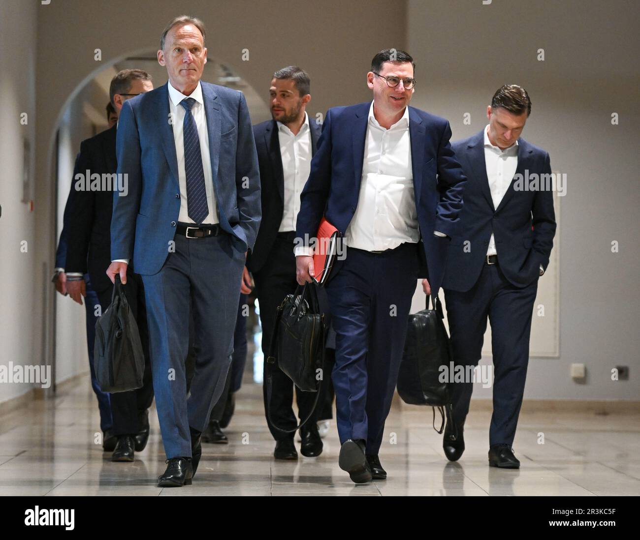 24 May 2023, Hesse, Frankfurt/Main: Hans-Joachim Watzke (l), Managing Director of Borussia Dortmund and Chairman of the DFL Supervisory Board, and Oliver Leki (2nd from right), CFO of SC Freiburg and one of the two Managing Directors of DFL GmbH, are on their way to the DFL General Meeting at Frankfurt Airport. The topic is the possible entry of an investor into the German Soccer League (DFL). Photo: Arne Dedert/dpa - IMPORTANT NOTE: In accordance with the requirements of the DFL Deutsche Fußball Liga and the DFB Deutscher Fußball-Bund, it is prohibited to use or have used photographs taken in Stock Photo