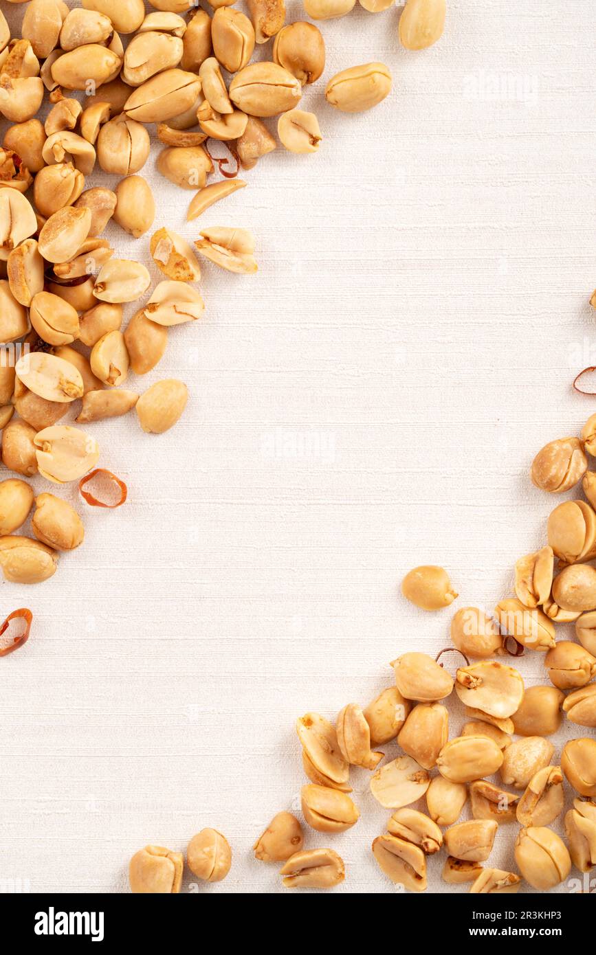 Spicy flavored peanut kernel spilling on white table background. Stock Photo