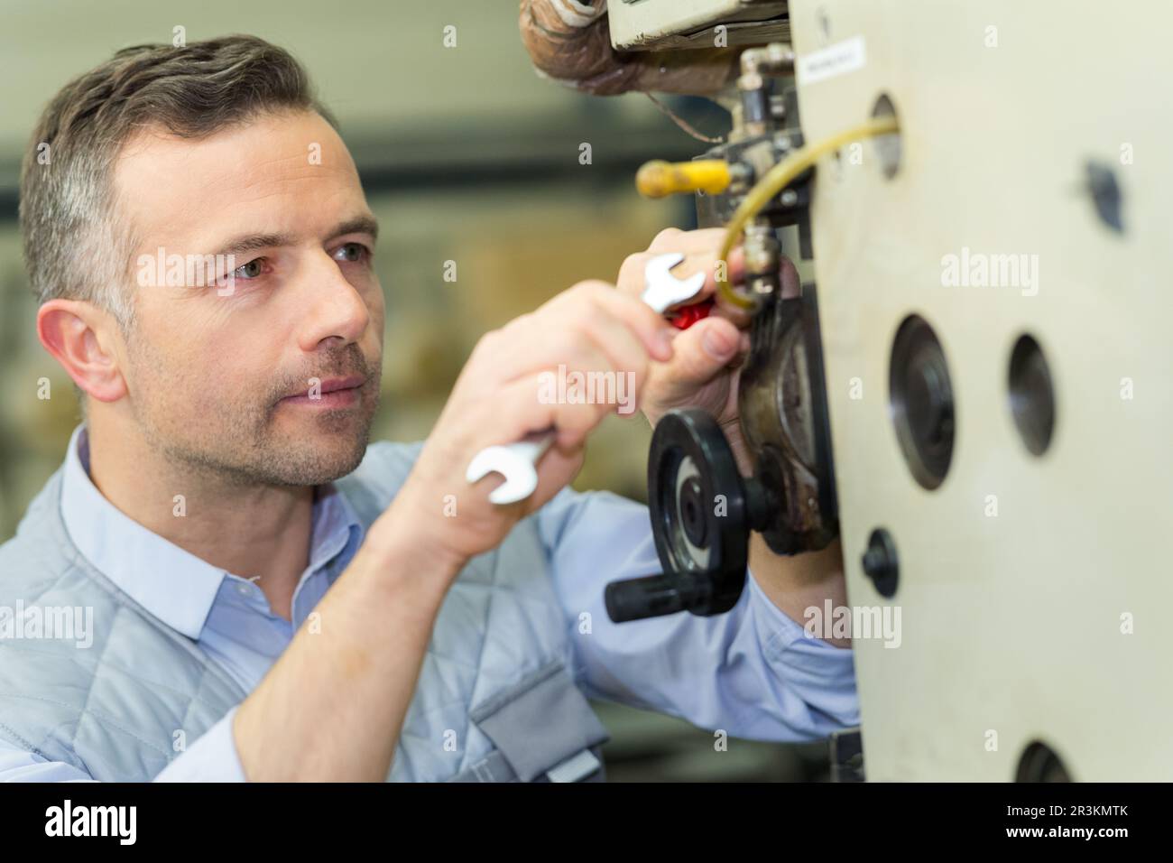 male technician using spanner machinery Stock Photo