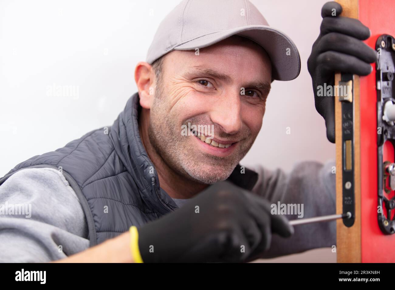 man installing door mechanism with screwdriver Stock Photo Alamy