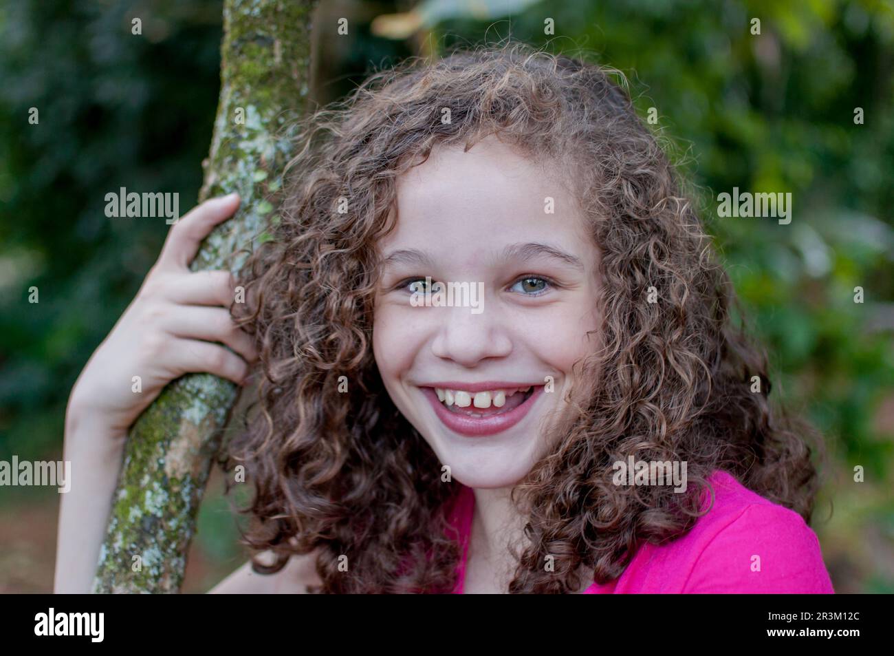 Portrait of curly girl smiling at camera Stock Photo