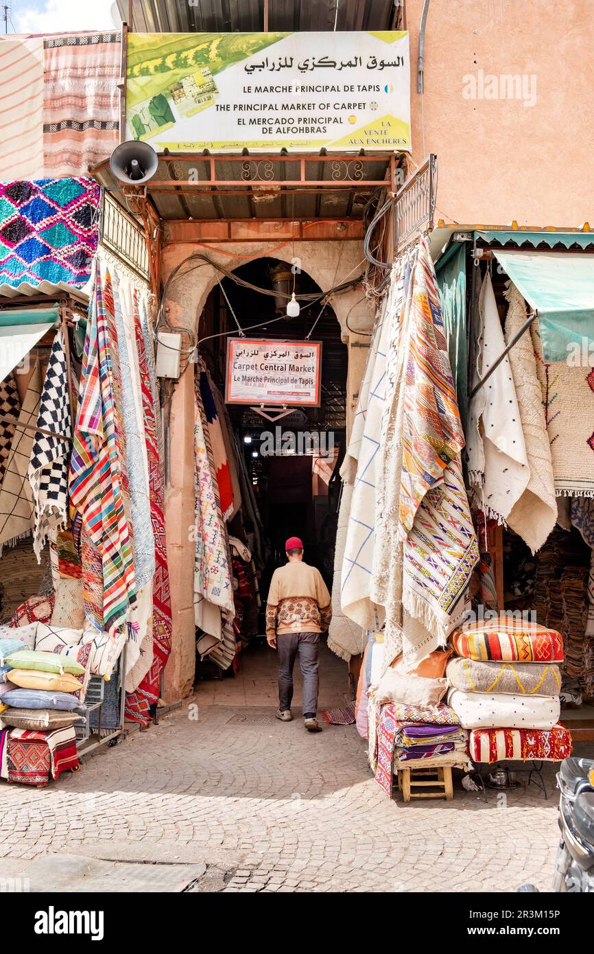 The entrance to the main carpet selling market within the Marrakesh, Morocco Central souks. Carpets hang from stalls either side of the entrance Stock Photo