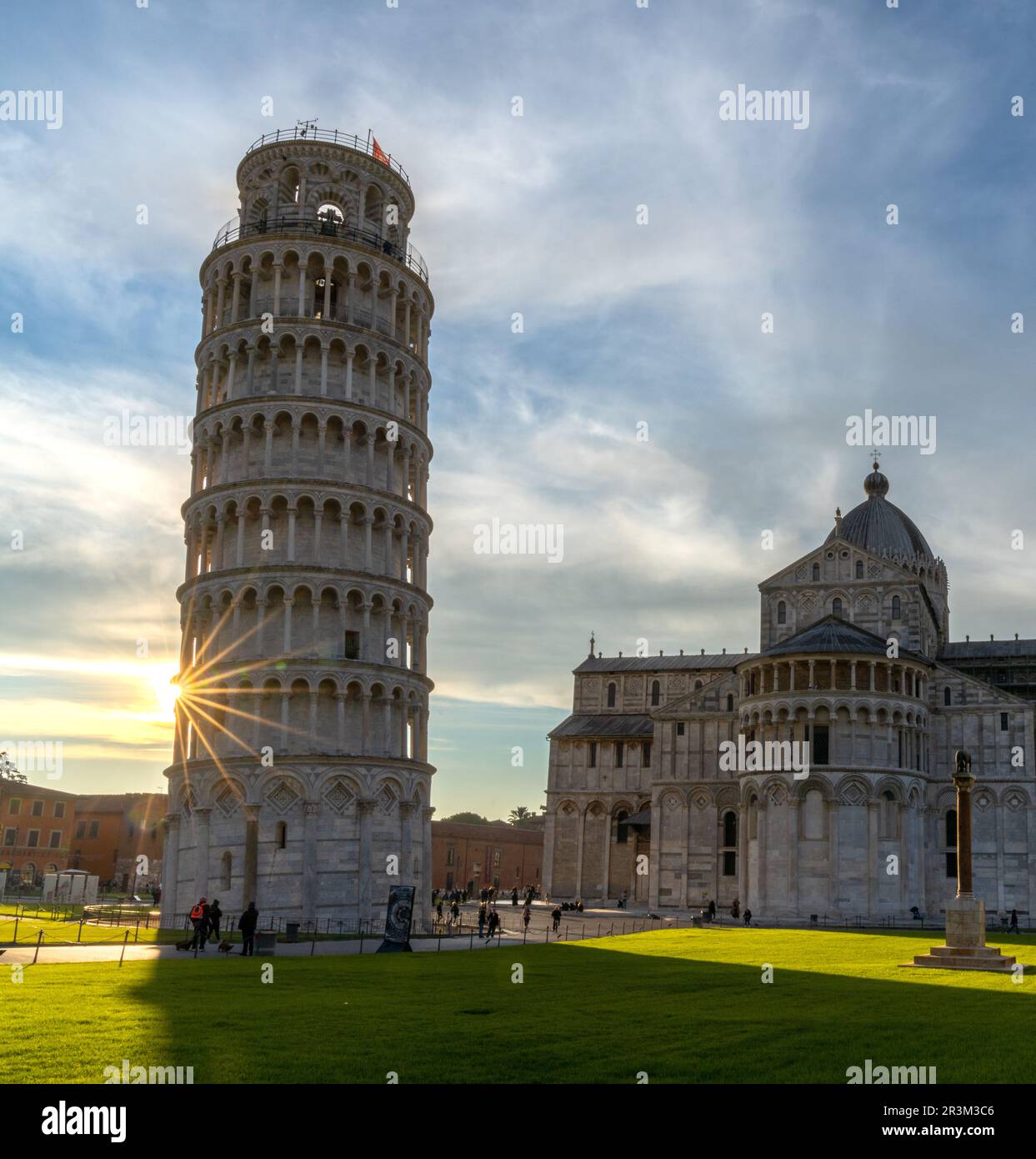 The Leaning Tower of Pisa and the Cathedral in warm evening light with a sunburst Stock Photo
