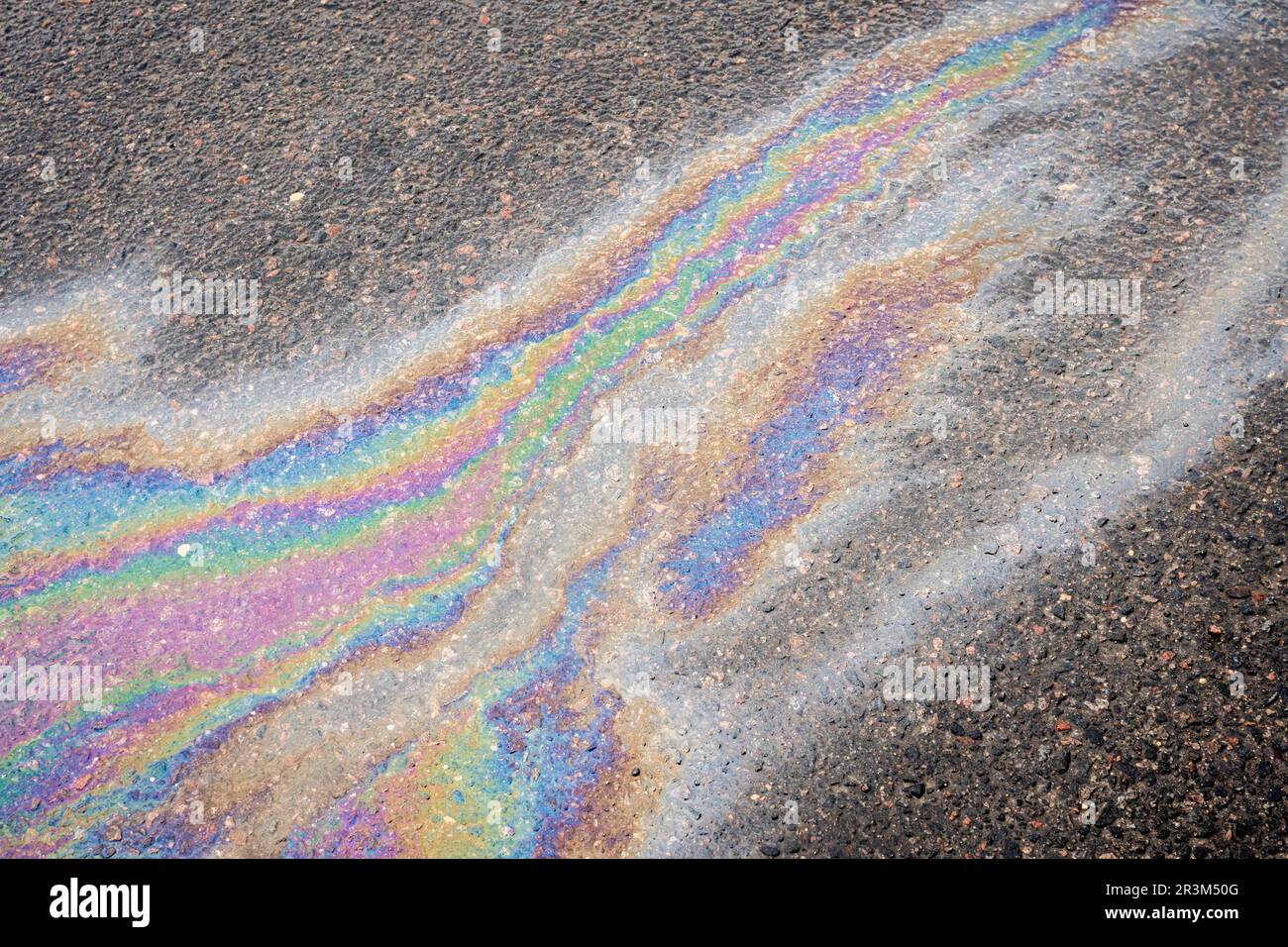 Oil stains from leaks in the car engine. Oil after rain makes spots
