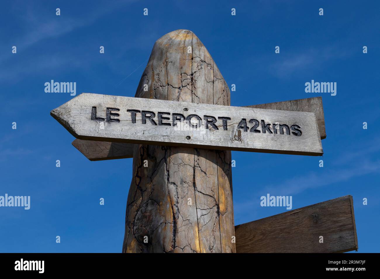 A wooden sign post with directions and distance to Le Treport in the Somme department of France. Travel and vacation concept. Stock Photo
