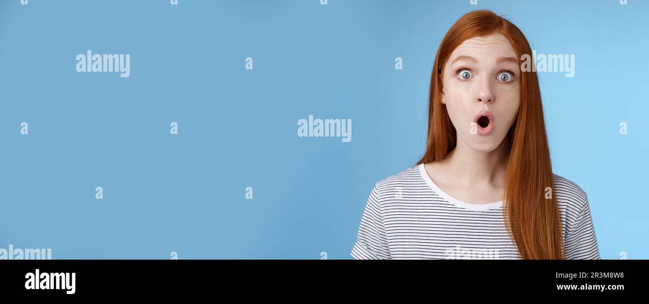 Wow omg fascinating. Impressed surprised amused good-looking redhead girl folding lips astonished wide eyes stunned reacting inc Stock Photo