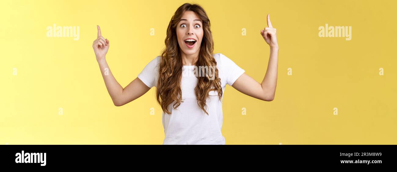 Fascinated speechless excited attractive curly-haired girl impressed stare camera surprised glad appreciation awesome gift recei Stock Photo