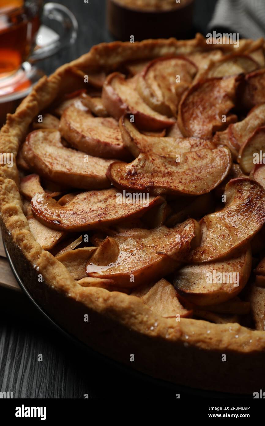 Delicious apple pie on black wooden table, closeup Stock Photo