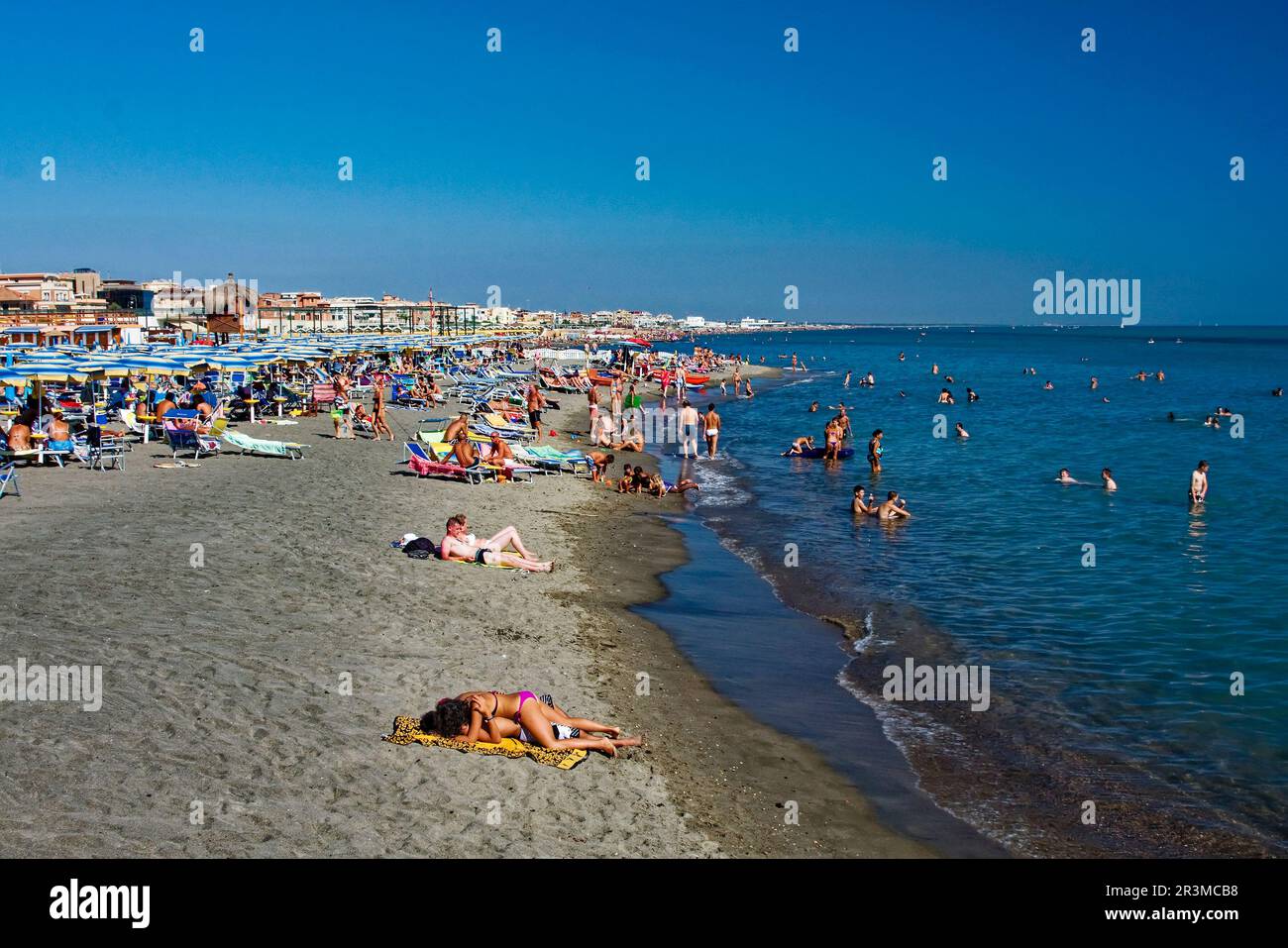 beach scene, sand, blue water, people, many umbrellas, chairs, relaxation, vacation, shoreline, swimming, Tyrrhenian Sea; Europe, Ostia; Italy; summer Stock Photo