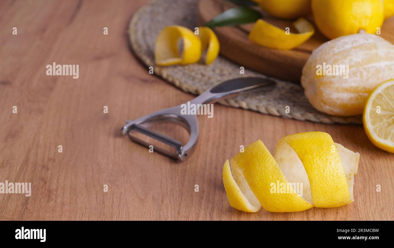 https://c8.alamy.com/comp/2R3MCBW/lemon-zest-rind-fresh-fruits-and-peeler-on-wooden-table-space-for-text-2R3MCBW.jpg