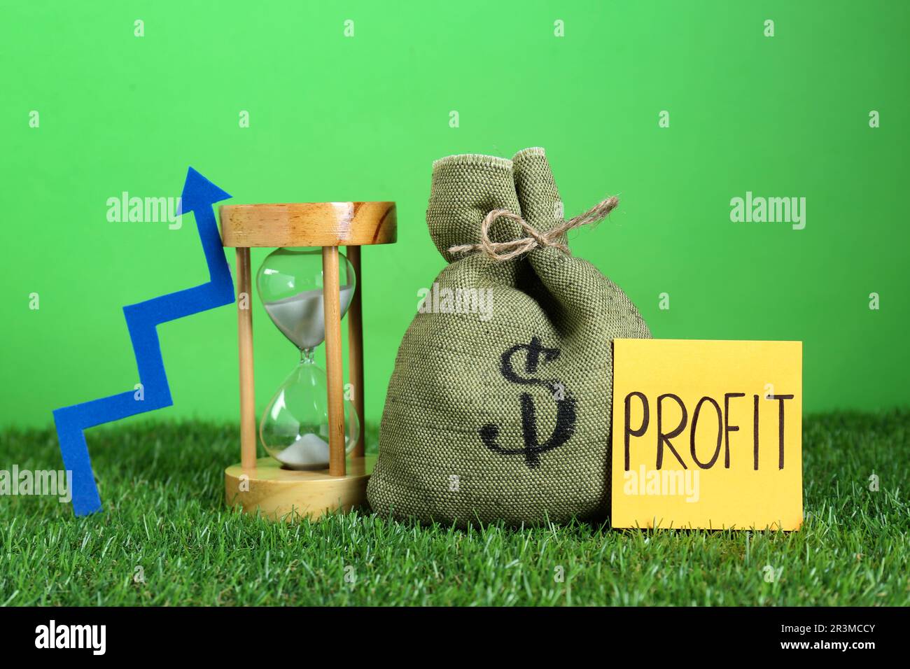 Sticky note with word Profit, money of bag, up arrow and sandglass
