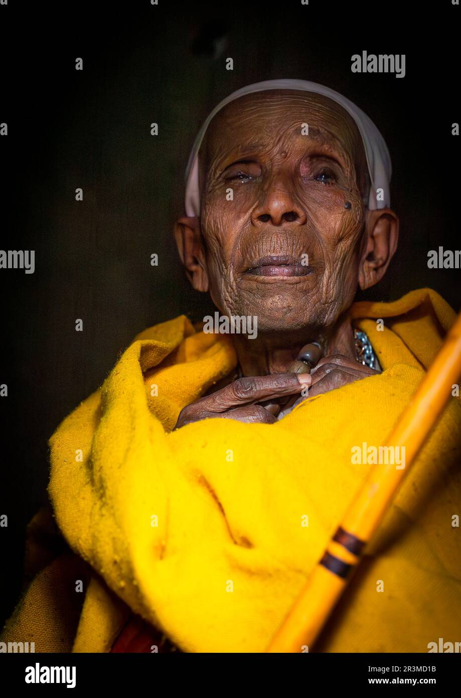 Old ethiopian nun in yellow shawl, Amhara Region, Lalibela, Ethiopia Stock Photo