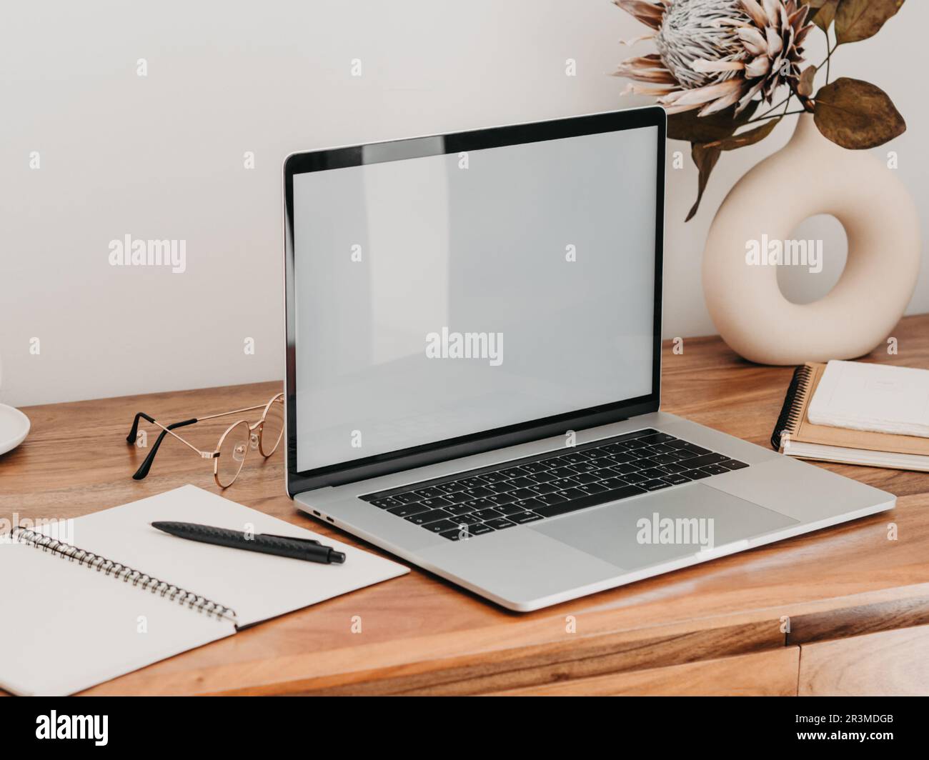 Laptop with blank screen on wooden table in home interior. Workplace ...
