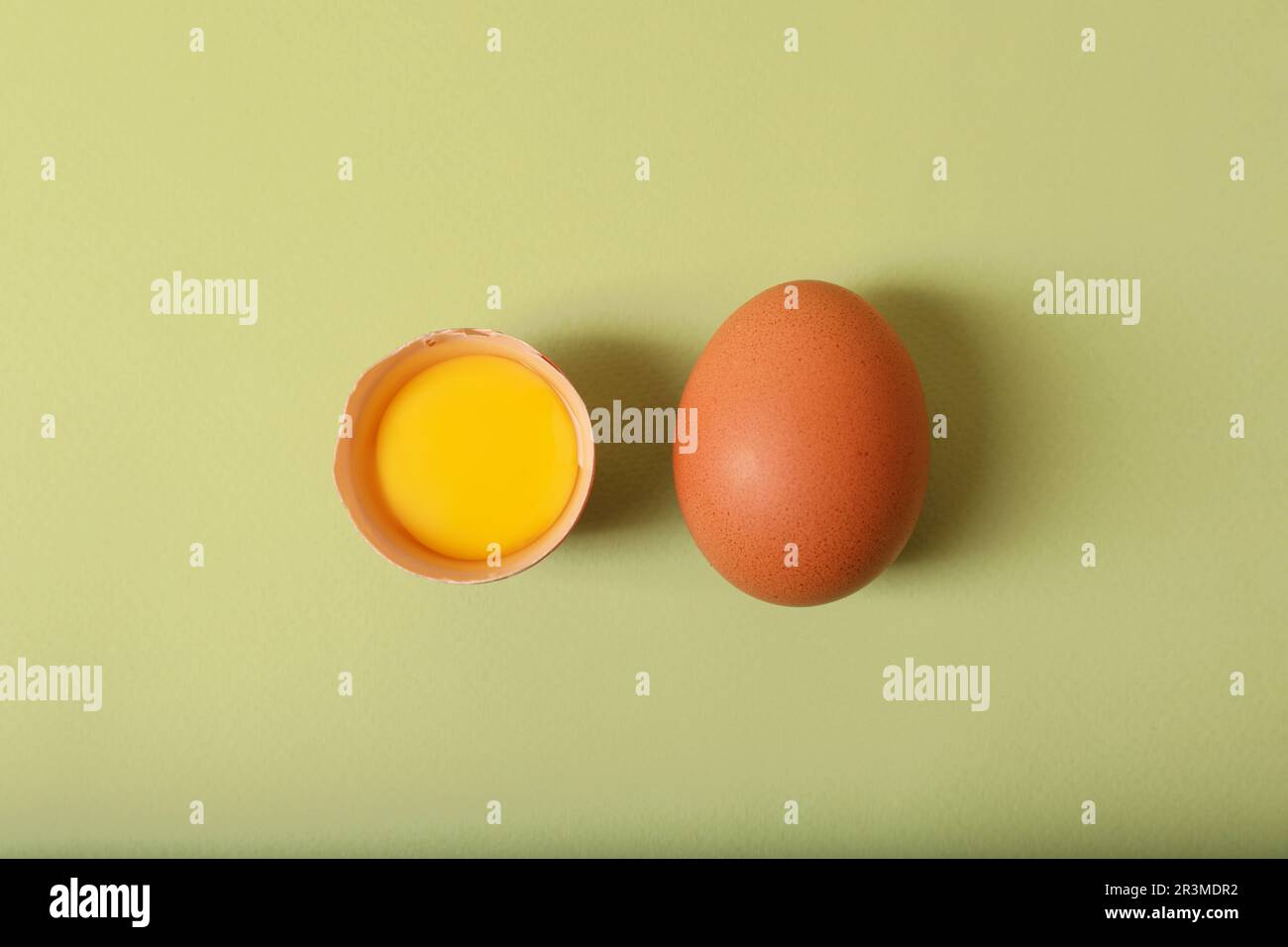 Cracked and whole chicken eggs on olive background, flat lay Stock ...