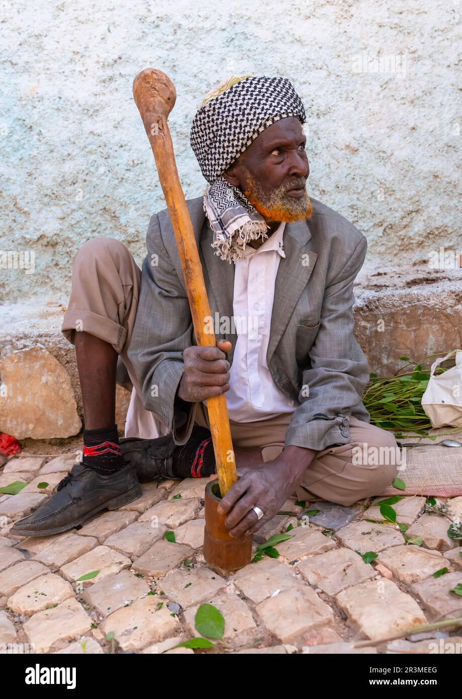 Old man without teeth crashing qat to chew In the street, Harari Region, Harar, Ethiopia Stock Photo