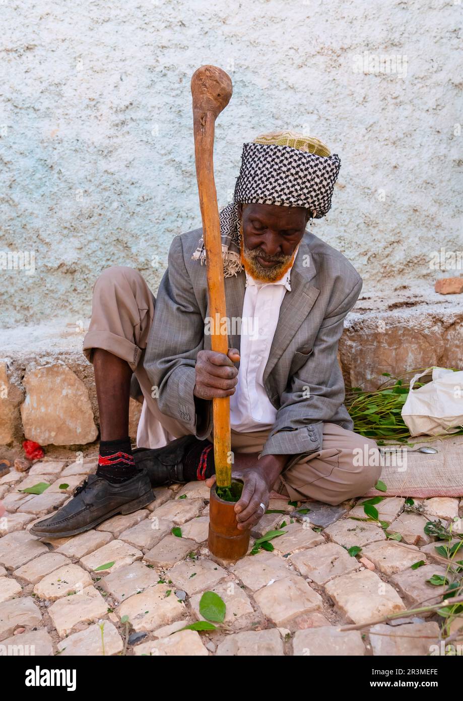 Old man without teeth crashing qat to chew In the street, Harari Region, Harar, Ethiopia Stock Photo