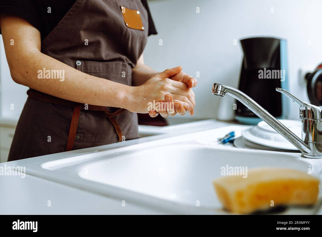 closeup hands woman dishwasher in kitchen while washing dishes Stock