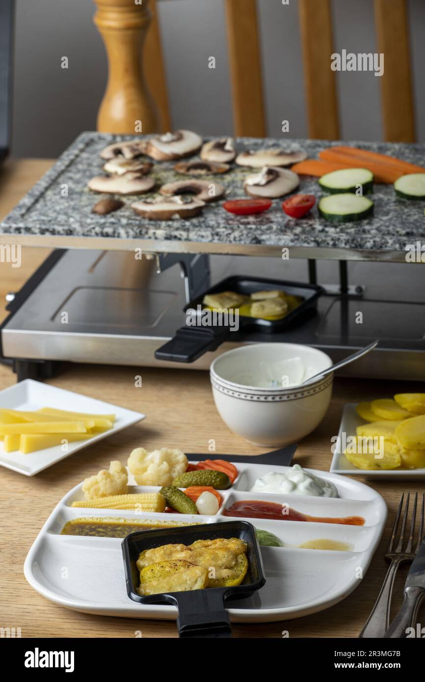 Raclette and a plate with potatoes Stock Photo