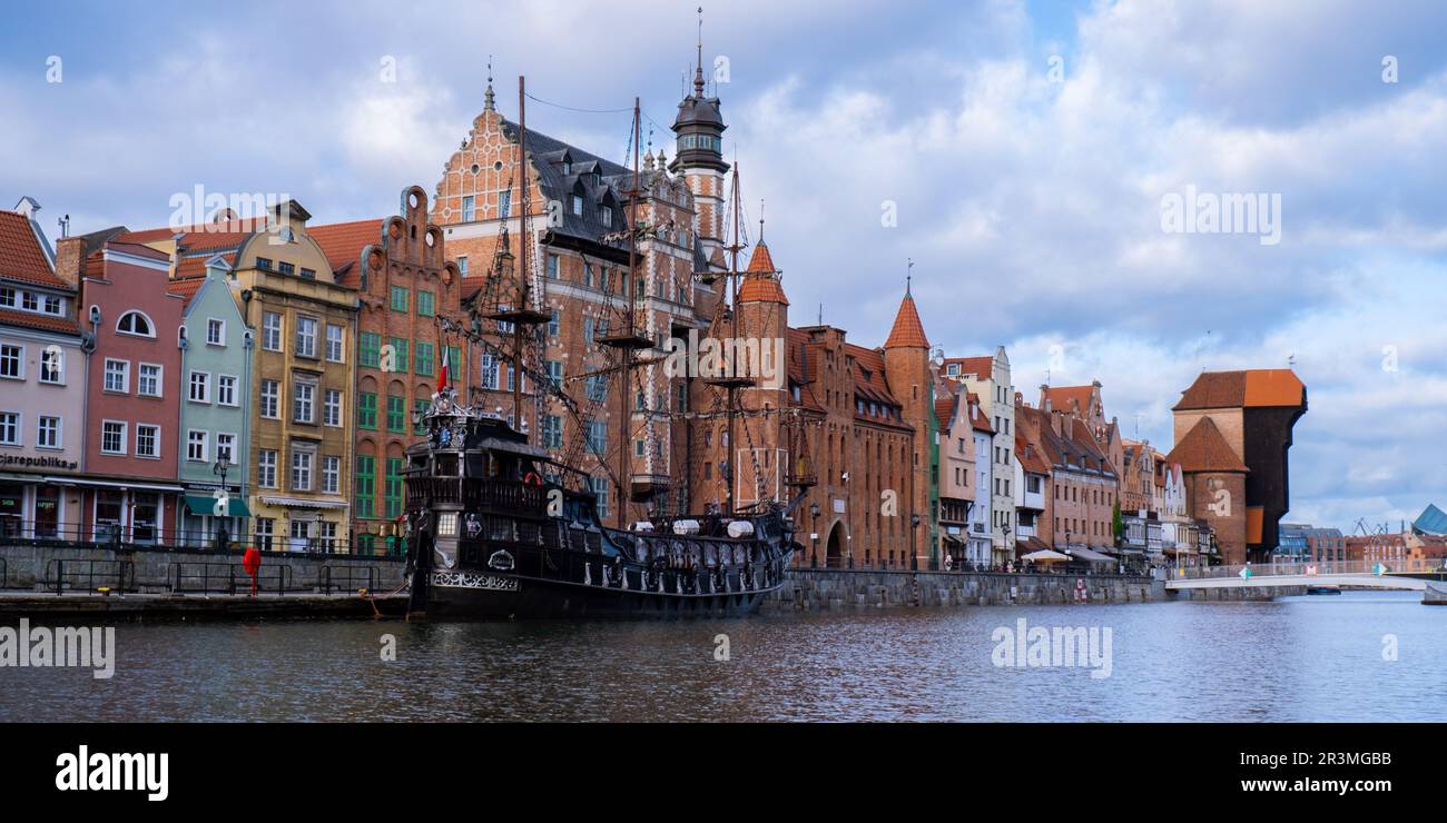 Beautiful old town of Gdansk over Motlawa river Vintage ship pirate caravels sailing on Motlawa river with historic port Crane i Stock Photo