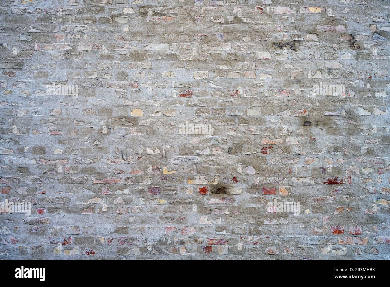 Background from a gray brick wall with with some plaster on it Stock Photo