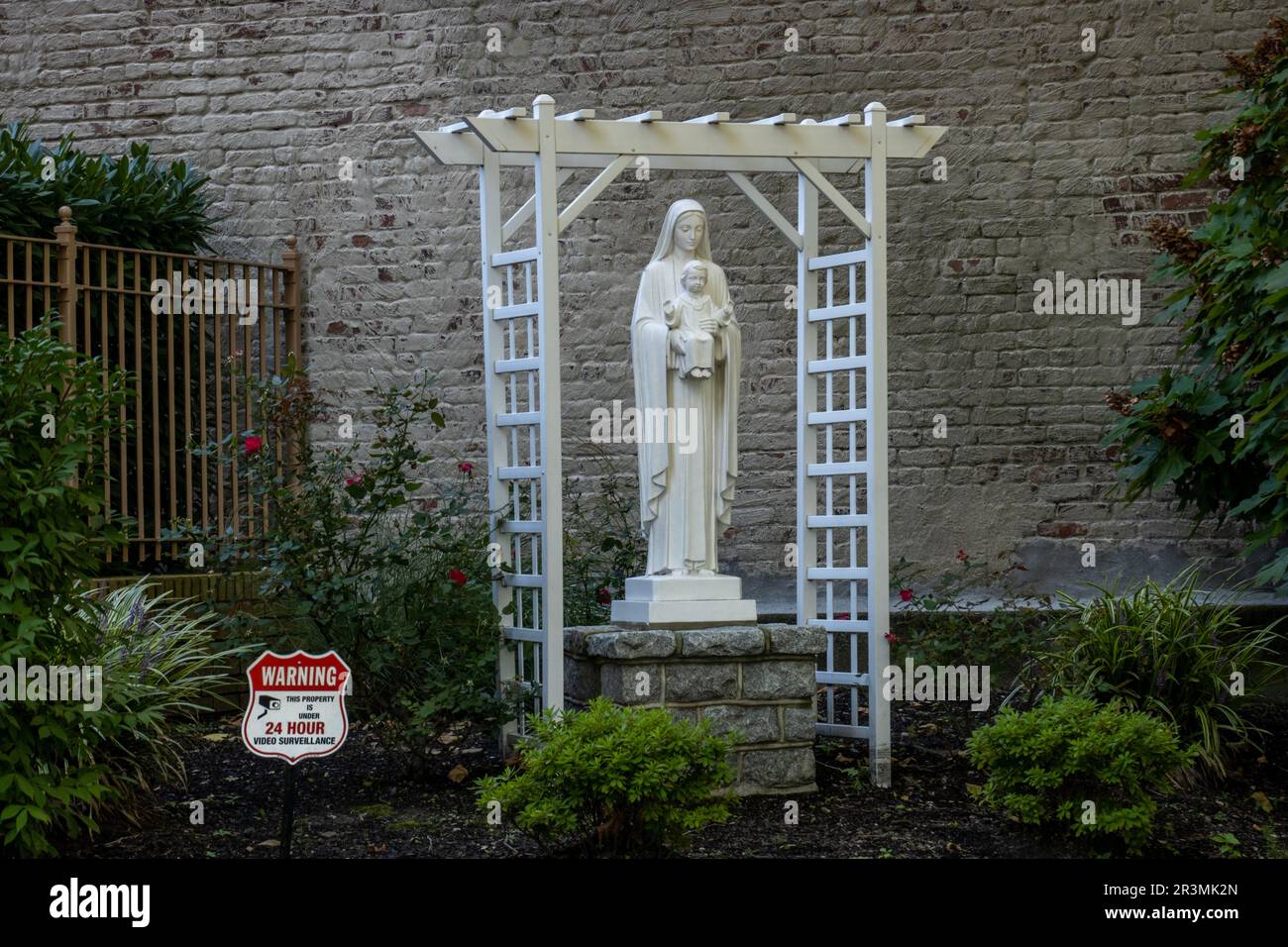 Mary and Jesus statue under 24 hour surveillance cameras in front of a church in Brooklyn NYC Stock Photo