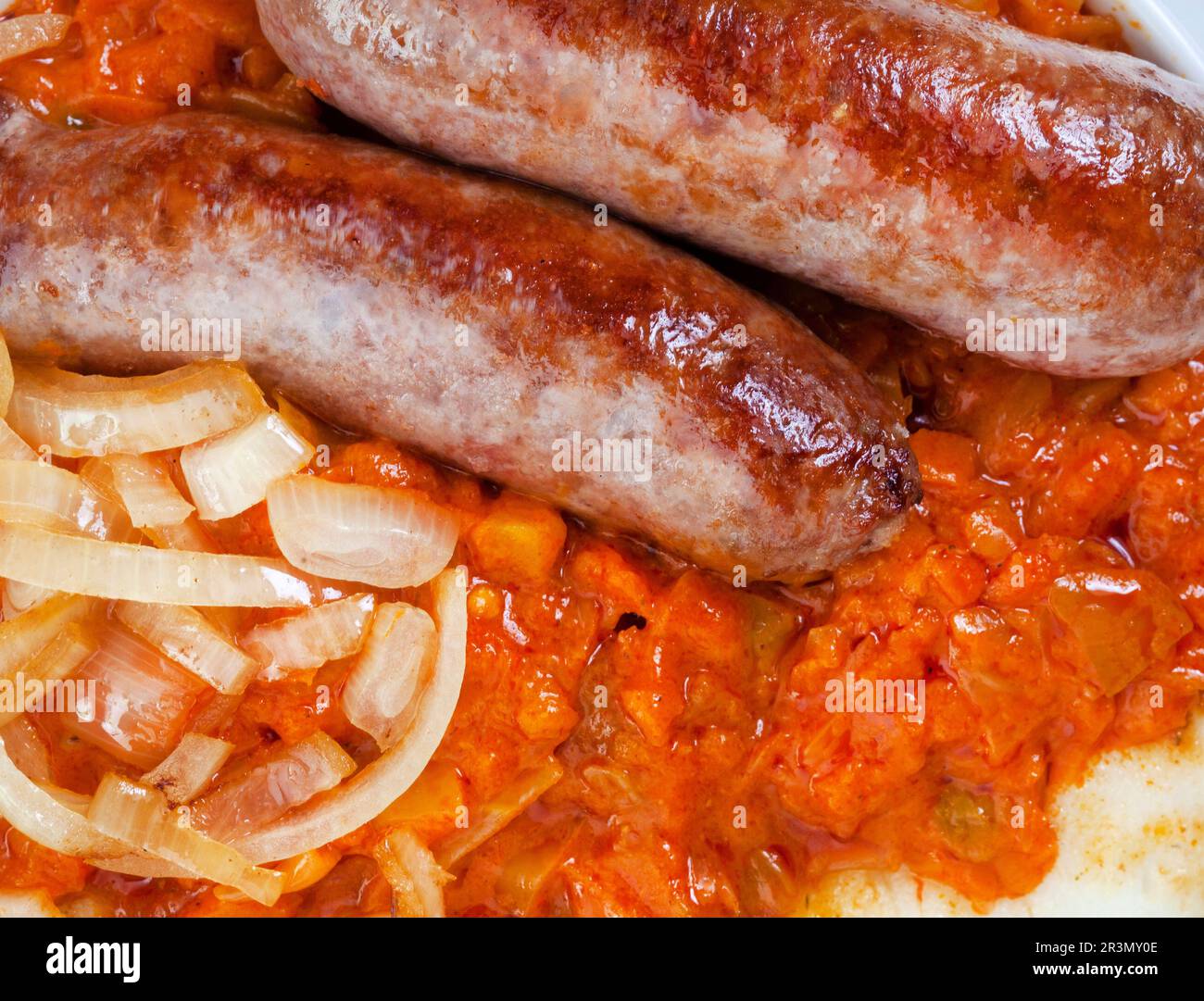 close up of Traditional South African Pap and Wors, sausage with popular maize meal staple covered with Chakalaka or relish Stock Photo