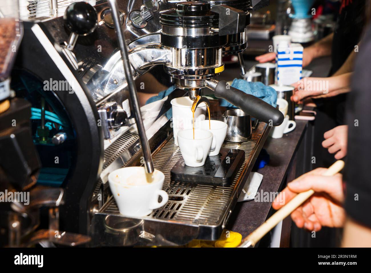 Young woman barista preparing coffee using machine in the cafe. Stock Photo