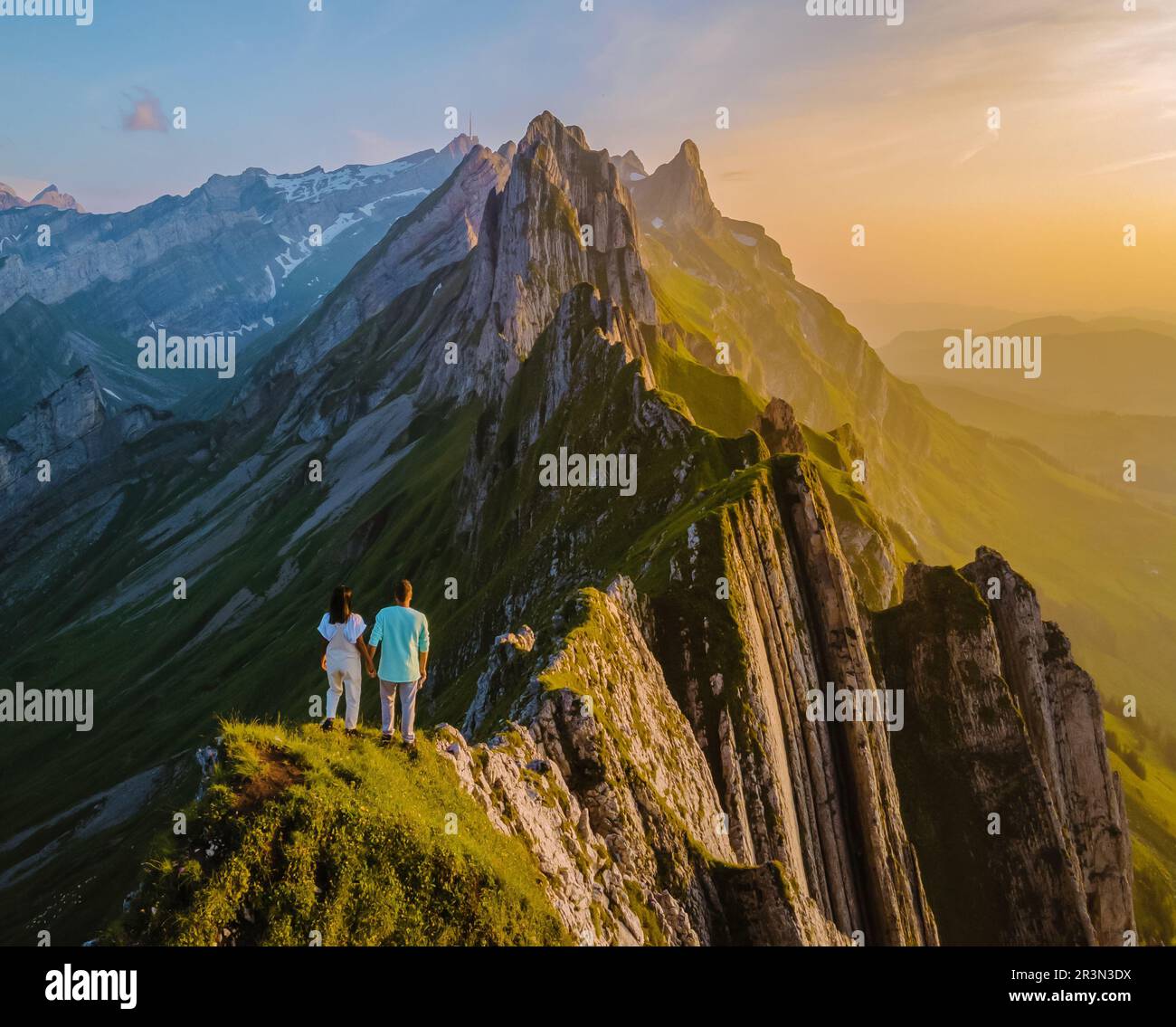 Couple at the hedge of a mountain watching sunset,Schaeffler mountain ...