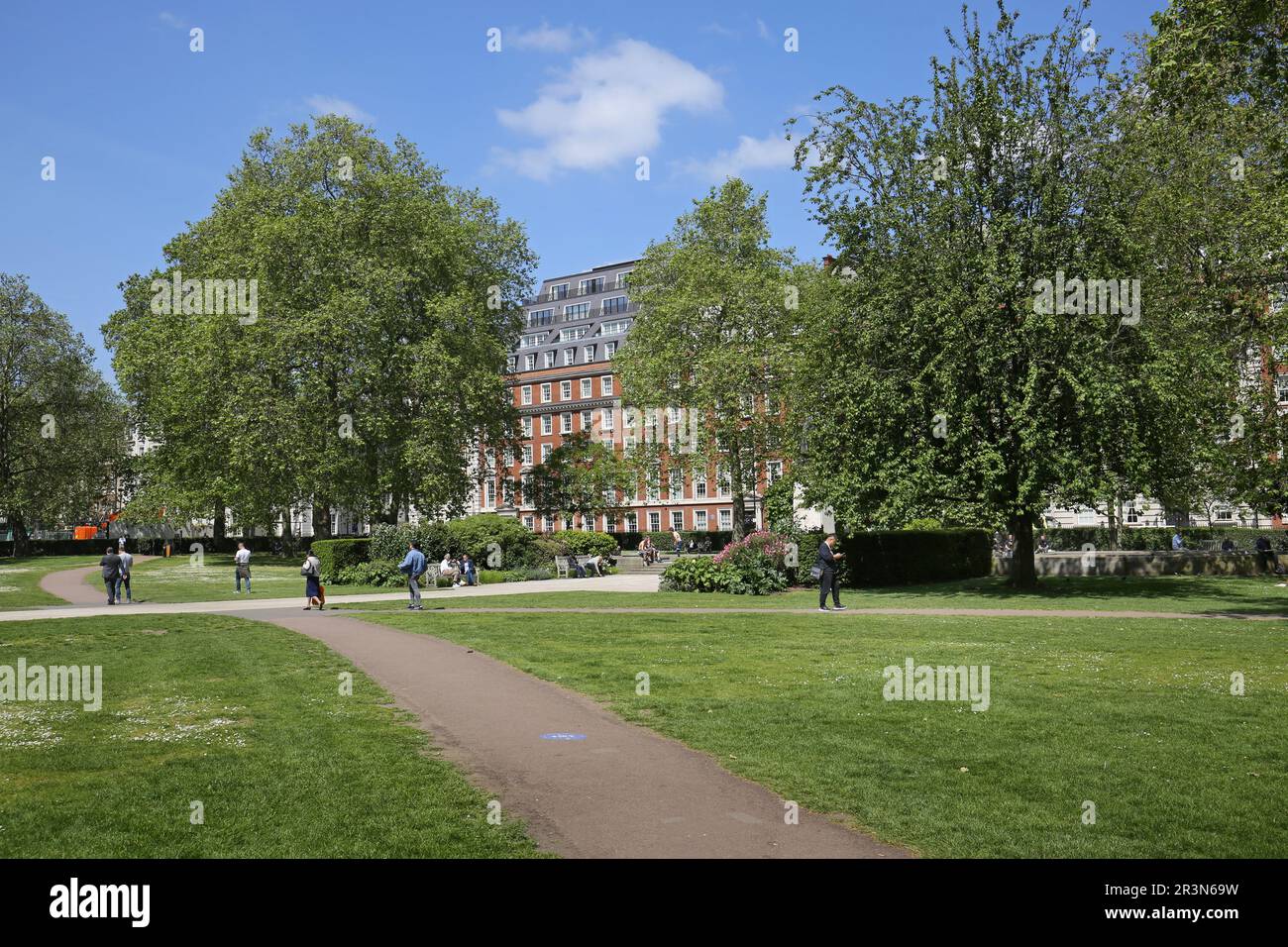 Grosvenor Square, Mayfair, London, UK. People enjoy sunny, summer weather in the central gardens. Stock Photo