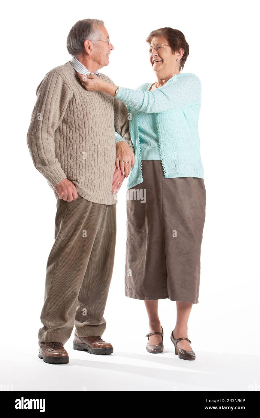 Senior Citizens: Keeping Up Appearances. A moment of grooming from an elegant senior couple. Full length portrait, isolated on white. From a series. Stock Photo