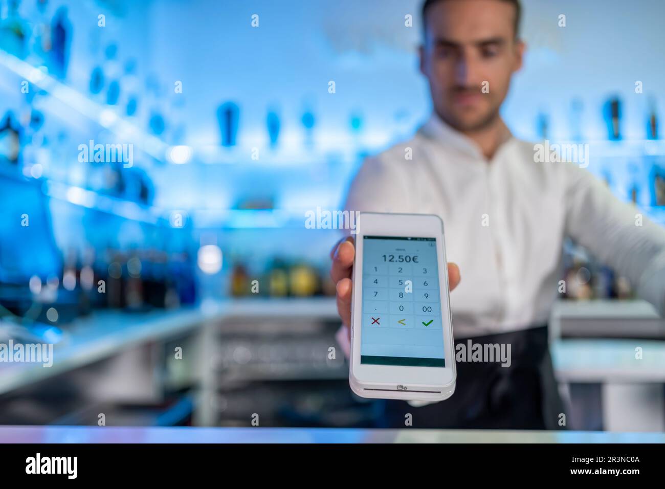 Unrecognizable male bartender showing digital POS machine screen with ...