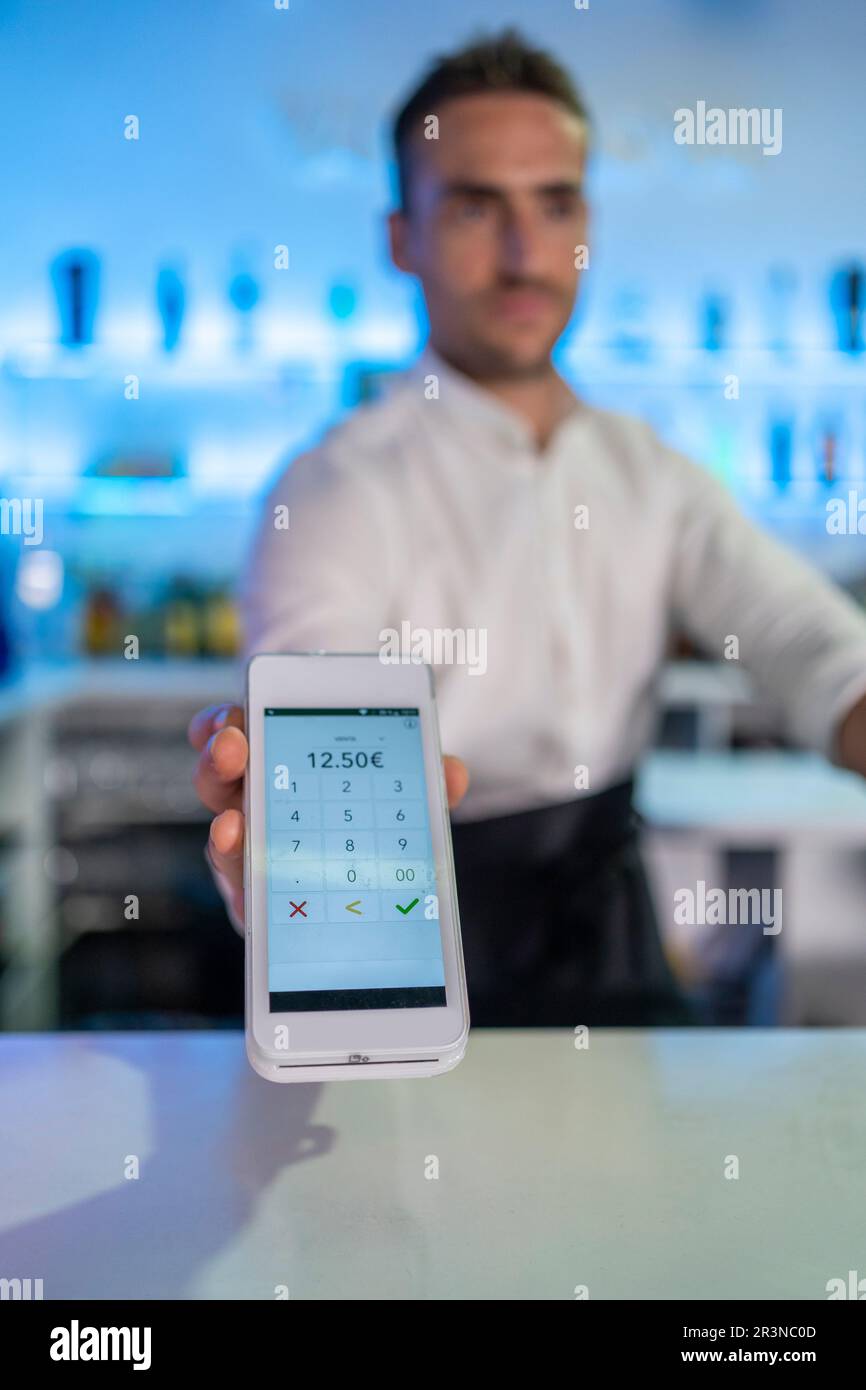 Unrecognizable male bartender showing digital POS machine screen with ...
