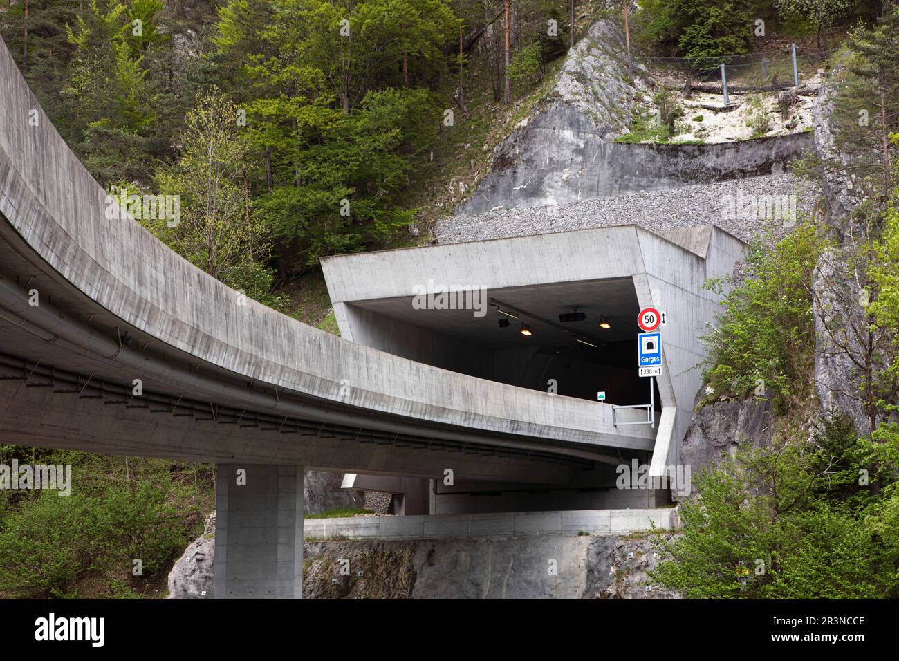 Entrance to a tunnel on a highway, pass trough mountain. Entry from flyover to road tunnel, highway in mountains, drive through mountain range and ext Stock Photo