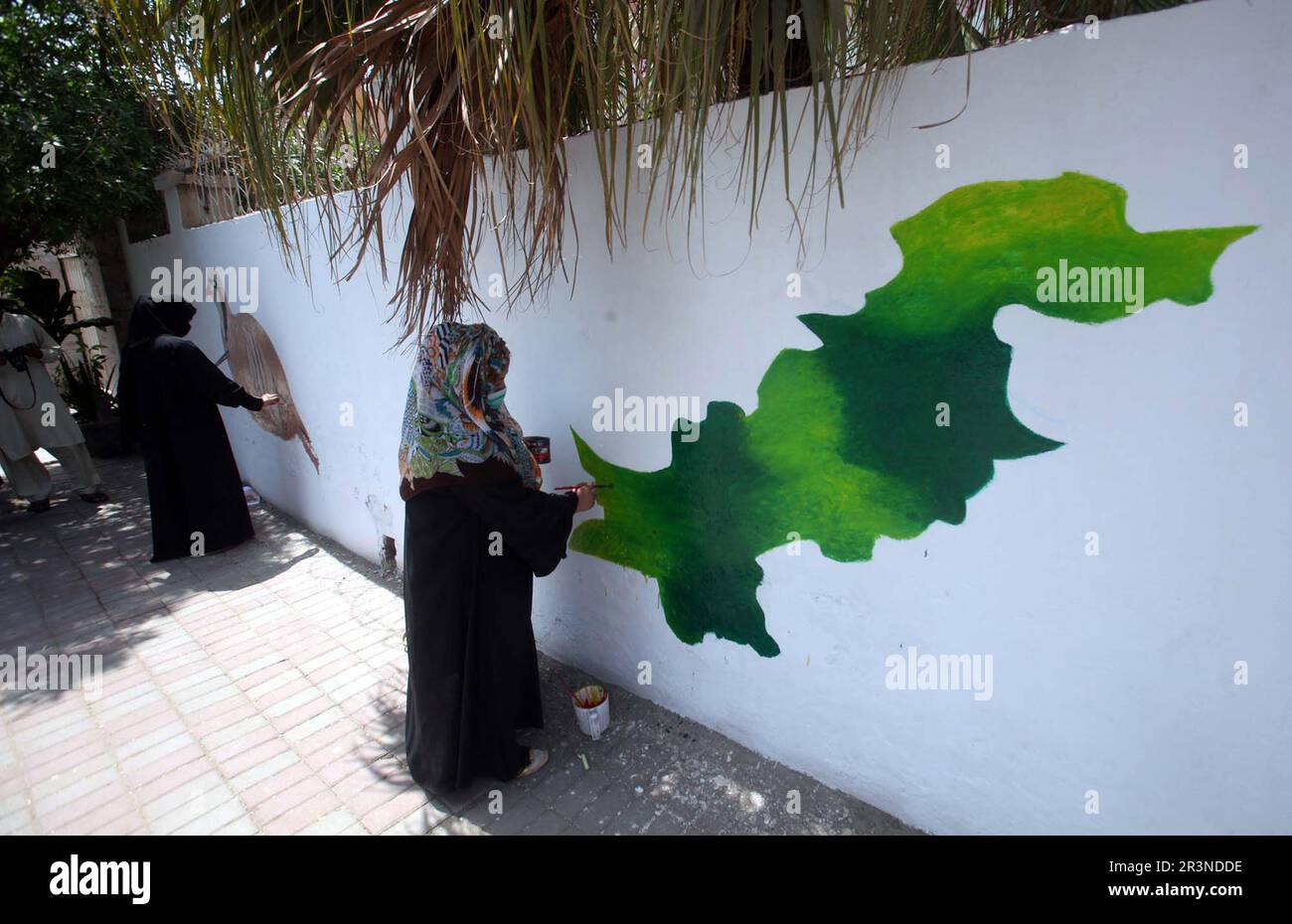 Fine artists busy in painting on a wall of Pakistan Post Office to show