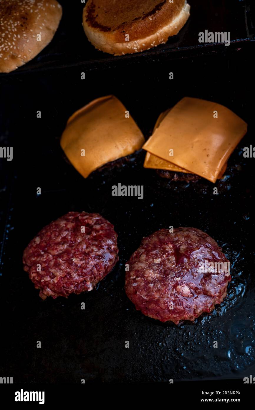 Hamburgers cooking on the grill. Beef or pork barbecue hamburger for hamburger. Hamburgers on bbq . Stock Photo