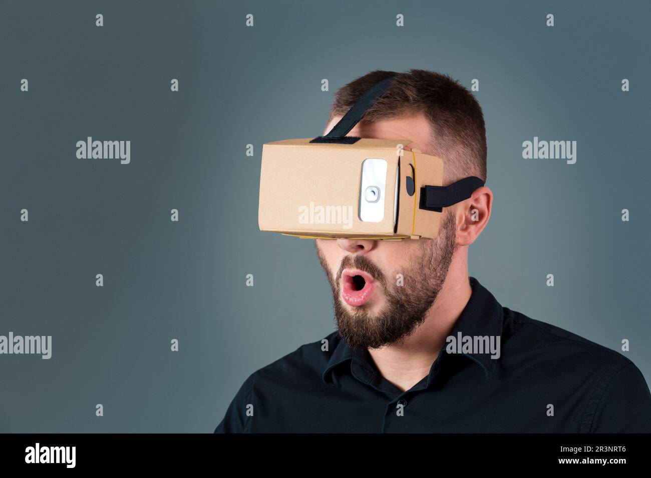 Man using a new virtual reality headset on grey background Stock Photo ...