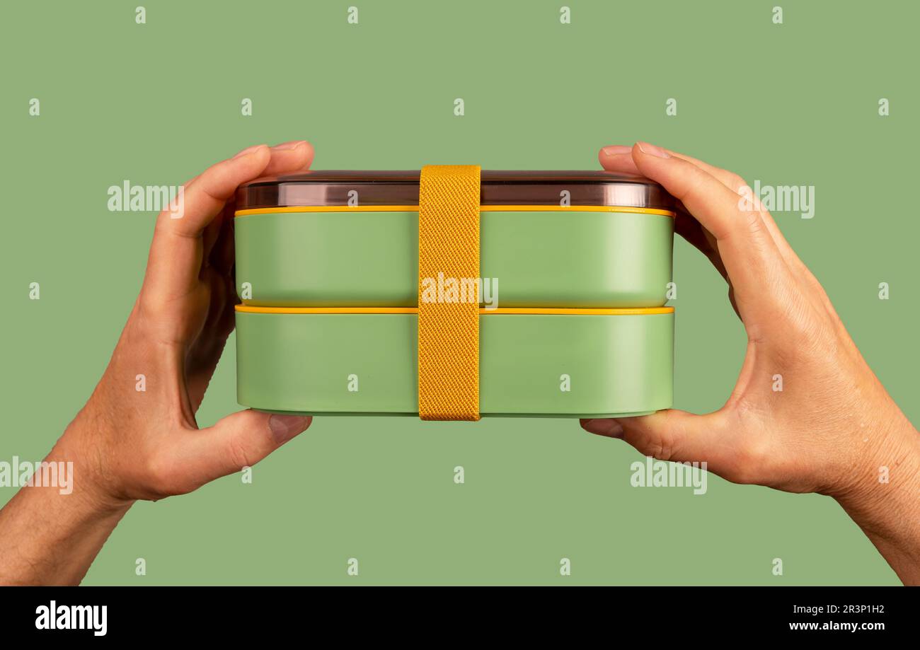 Male hands holding double lunch boxes with ribbon. Lunchbox Stock Photo