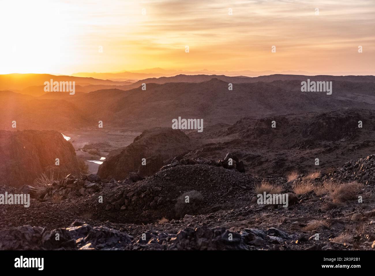 Stunning view of black and red rocky mountains with a river on the bottom Stock Photo
