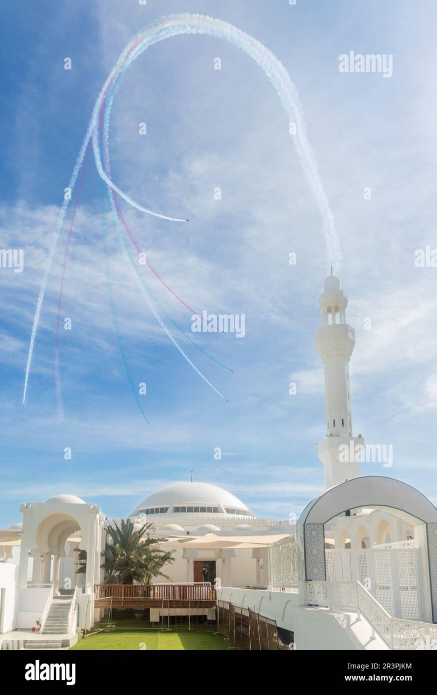 Jets stunts with smoke traces over white Alrahmah mosque, Jeddah, Saudi Arabia Stock Photo