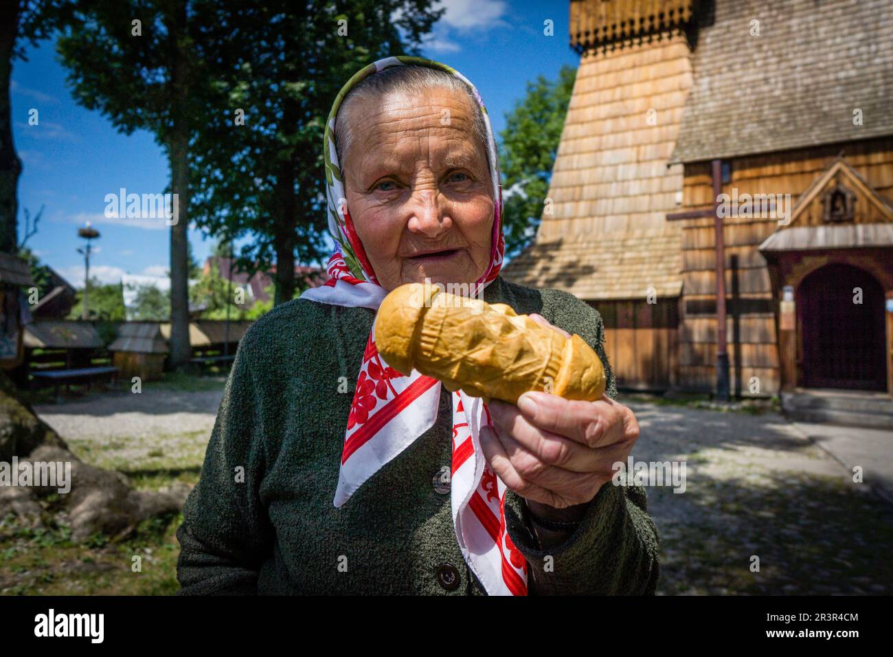 aldeana vendiendo queso Oscypeck frente a la iglesia de madera de Dbno , voivodato de la Pequeña Polonia, Cárpatos, Polonia, europe. Stock Photo