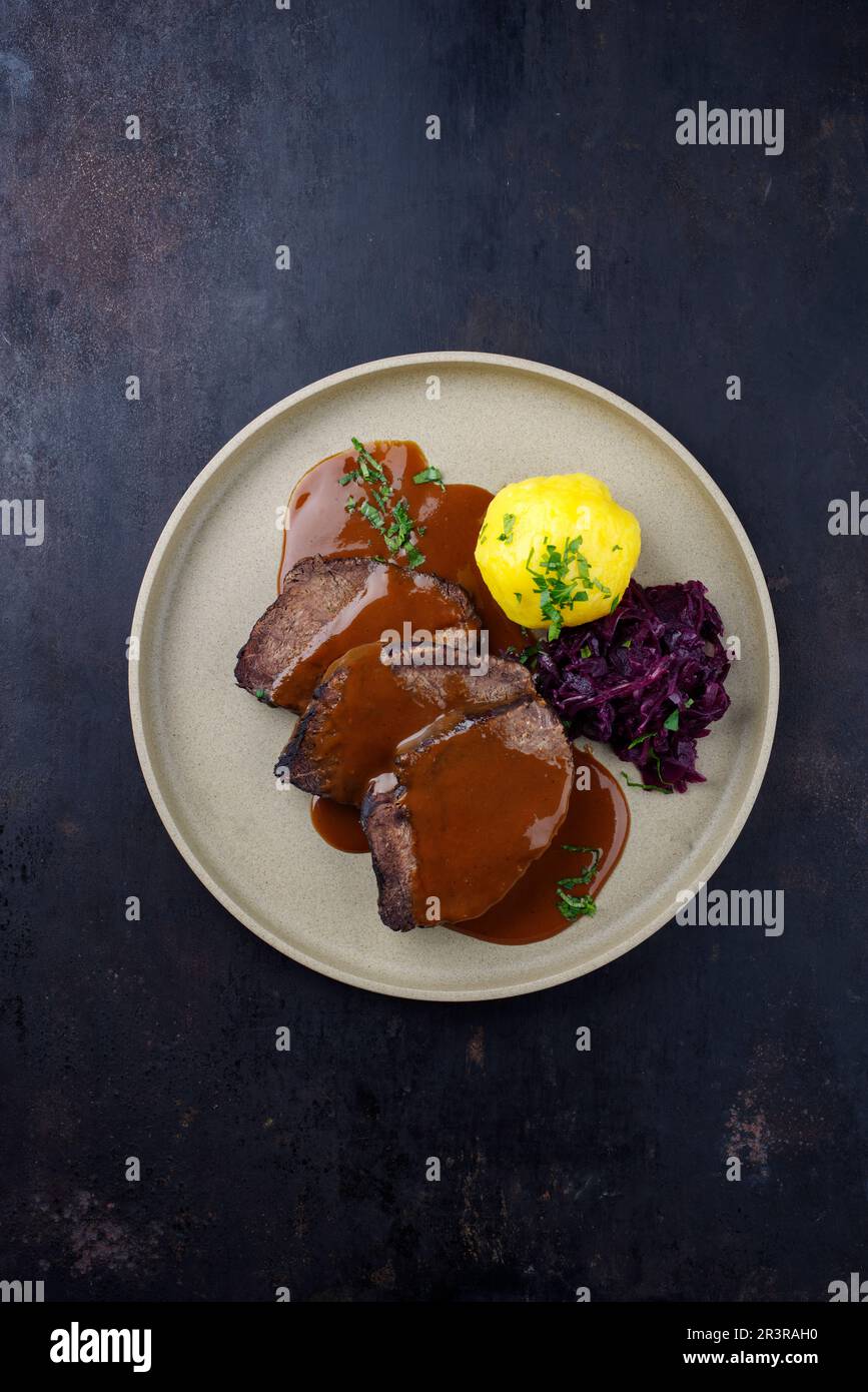 Traditional braised marinated German Sauerbraten from beef with blue