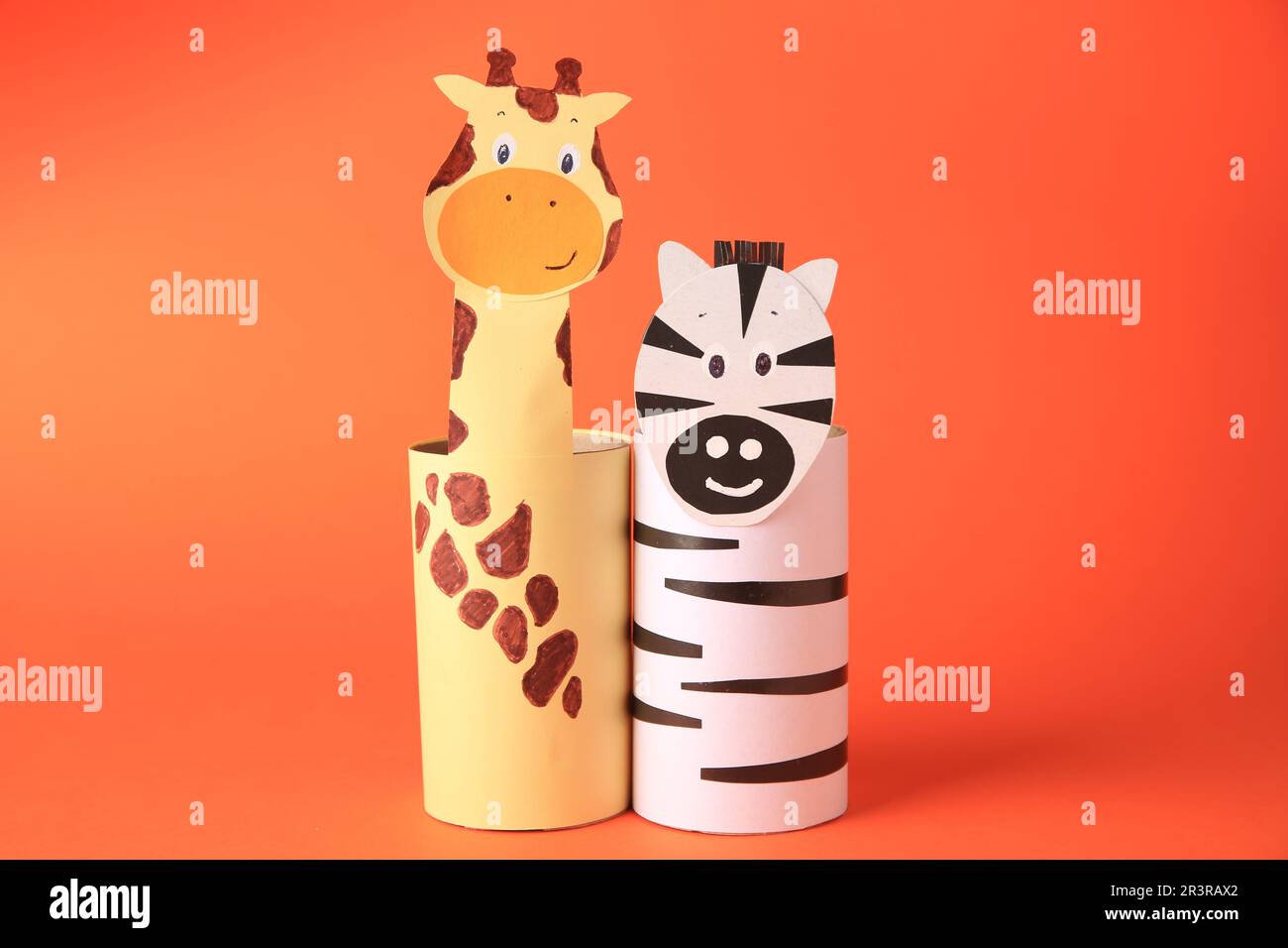 Toy giraffe and zebra made from toilet paper hubs on orange background. Children's handmade ideas Stock Photo