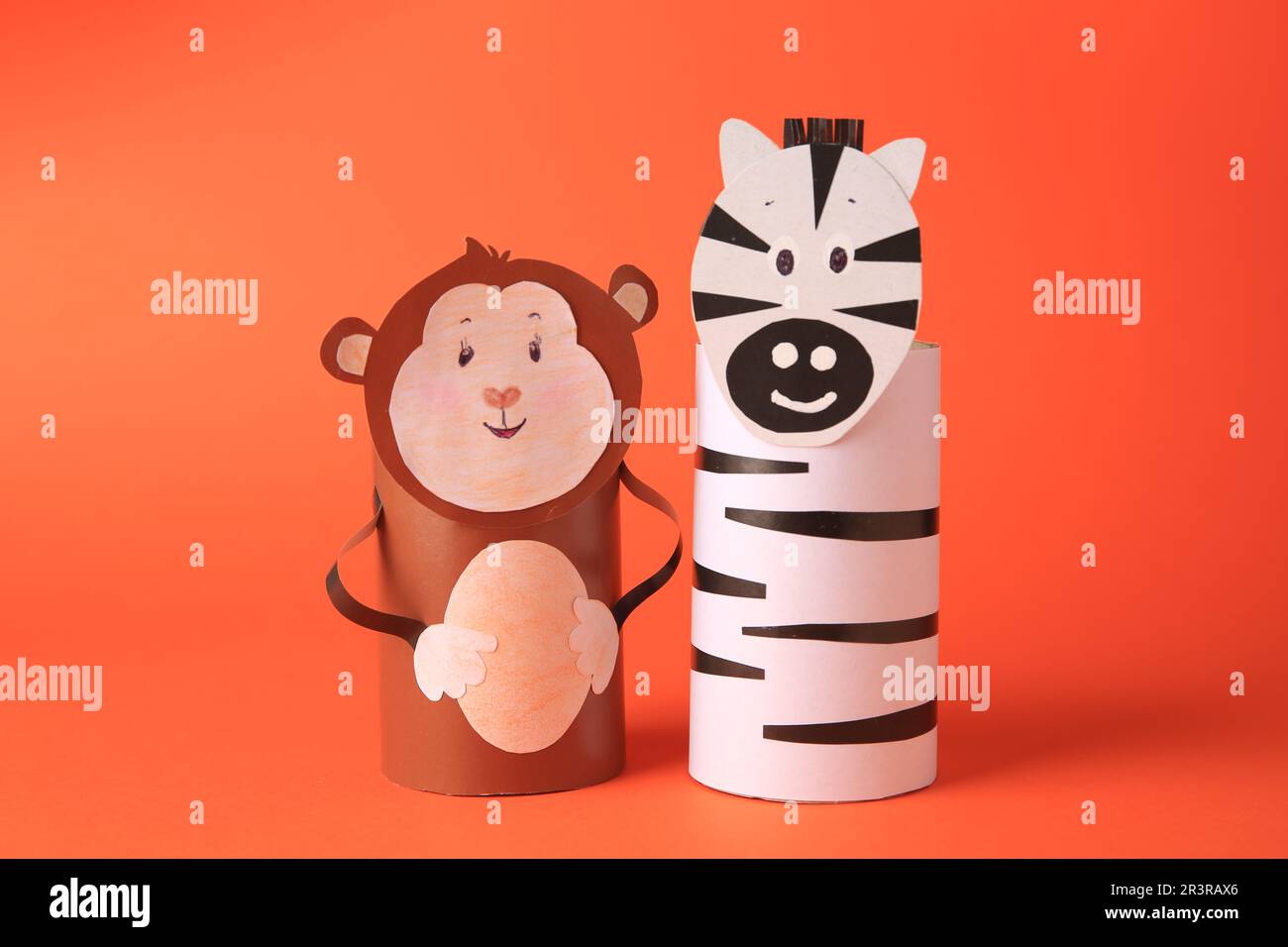Toy monkey and zebra made from toilet paper hubs on orange background. Children's handmade ideas Stock Photo